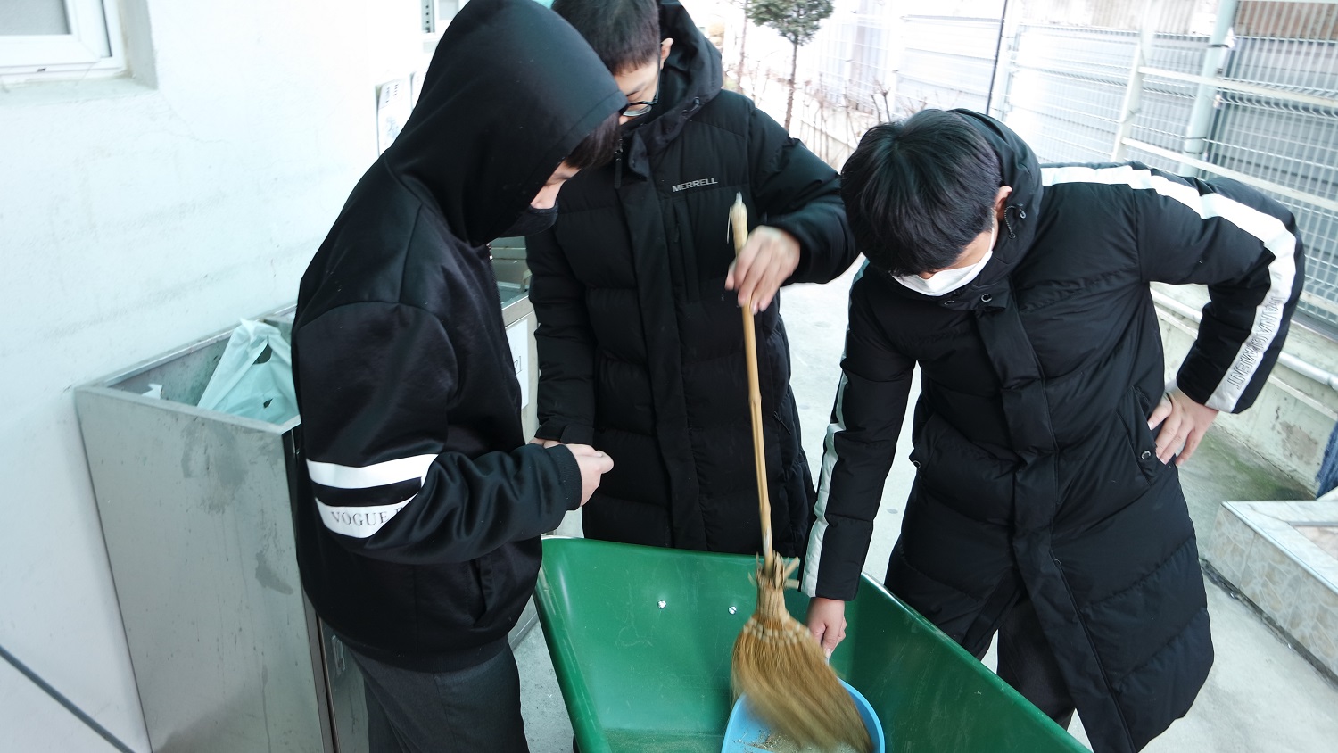 세 친구가 함께 수레 속 쓰레기를 청소하는 모습