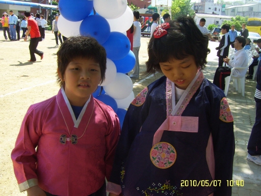 정현이와 성경이가 한복을 곱게 입고 포즈를 취하고 있는 장면입니다.