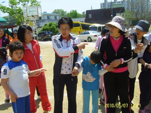 태건이와 정현이가 선생님들과 함께 공굴리기를 준비하고 있는 모습입니다.