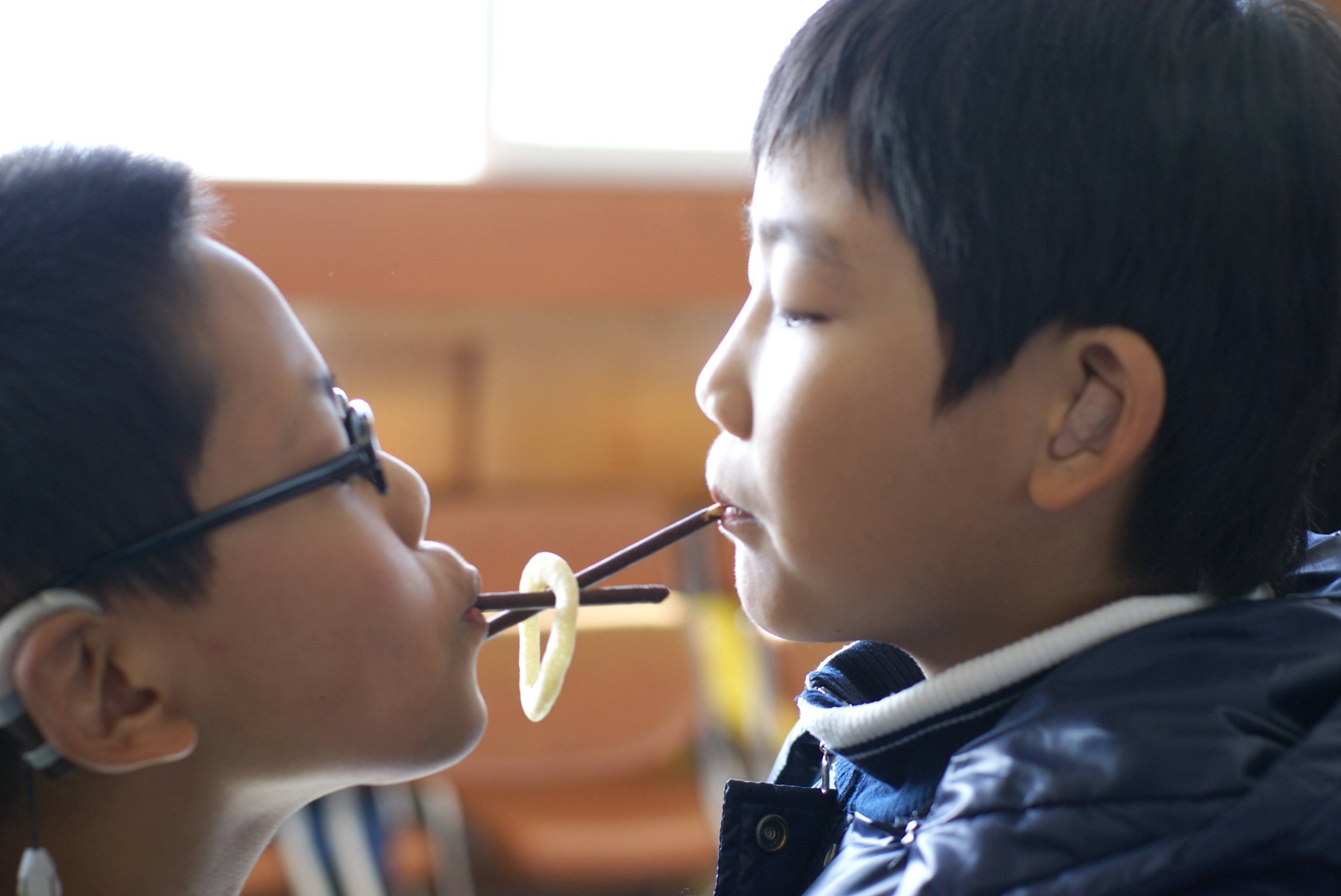 빼빼로를 입에 물고 양파링을 뒷 사람에게 건네주고 있어요.