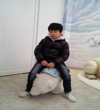 백혜원 학생이 하얀곰 모형위에 앉아 있는 모습입니다