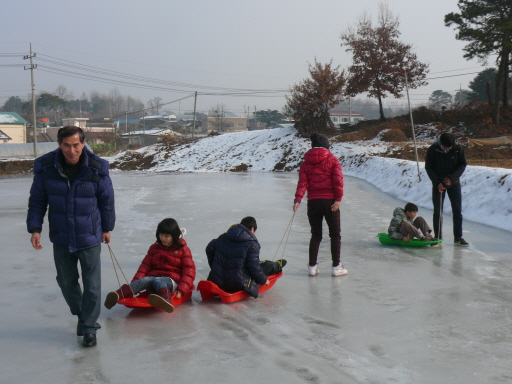 학생들이 얼음판위에서 썰매를 타는 모습입니다.