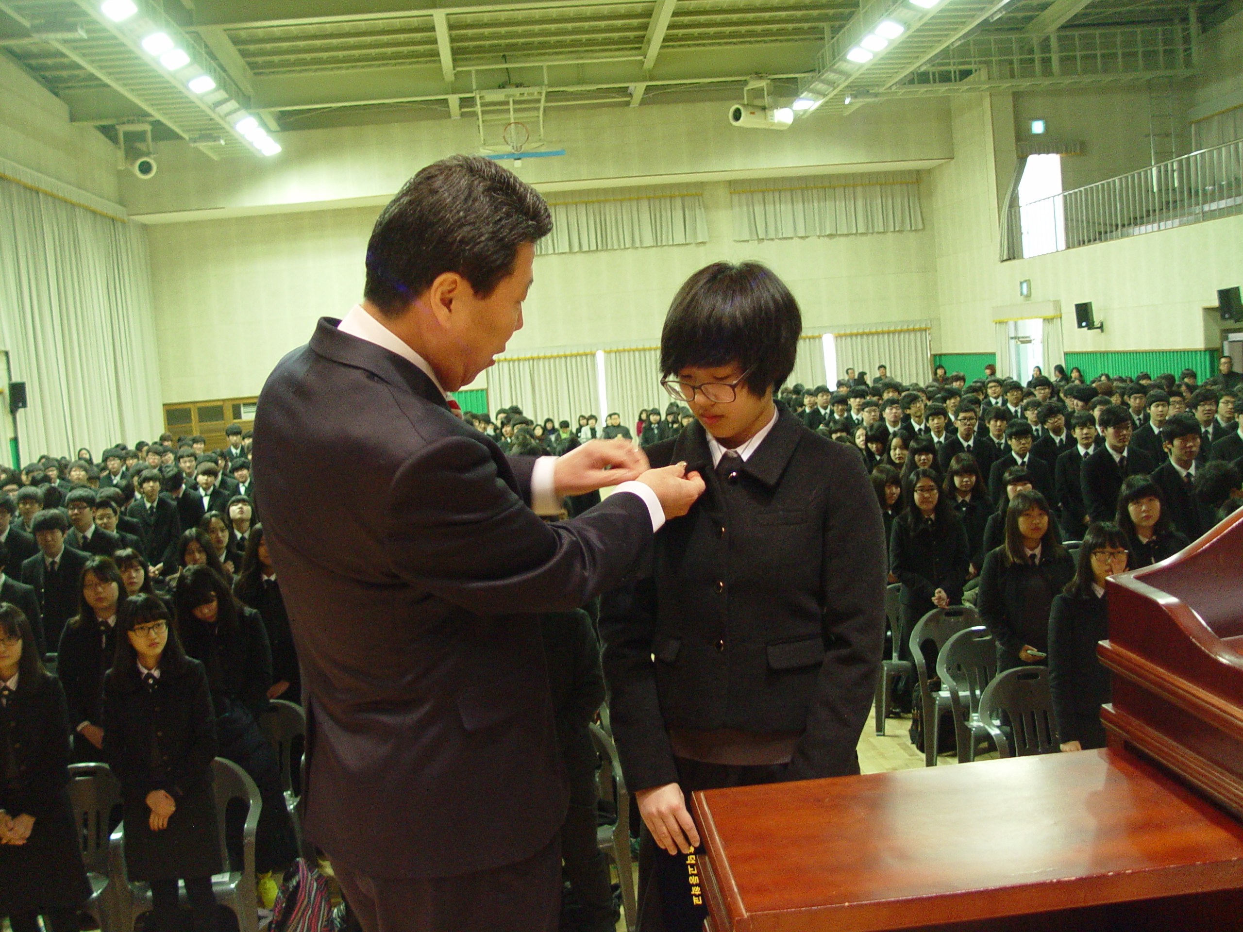 학생대표에게 학교뺏지 달아주기