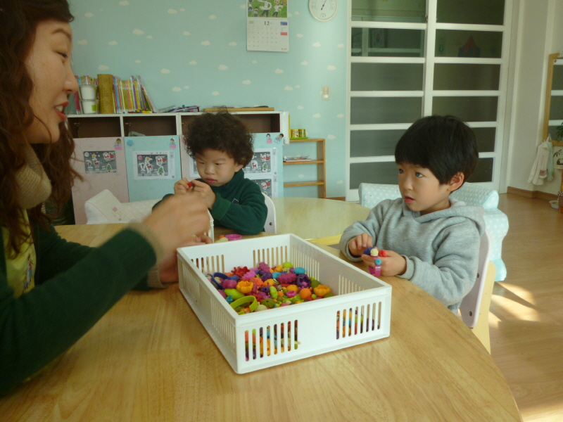 유치원 학생 2명이 선생님과 함께 미술놀이를 하고 있다.