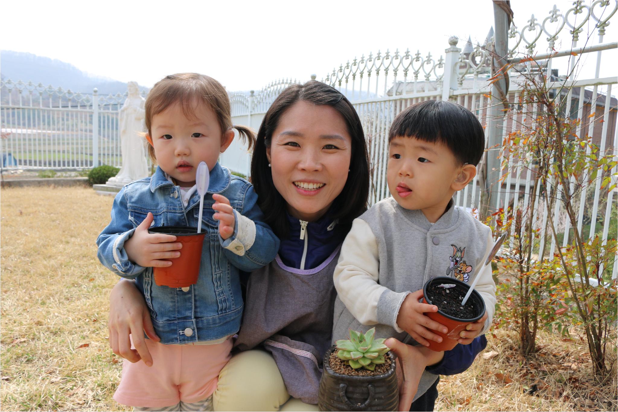 씨앗을 심은 화분을 들고 사진 찍고 있는 새싹반