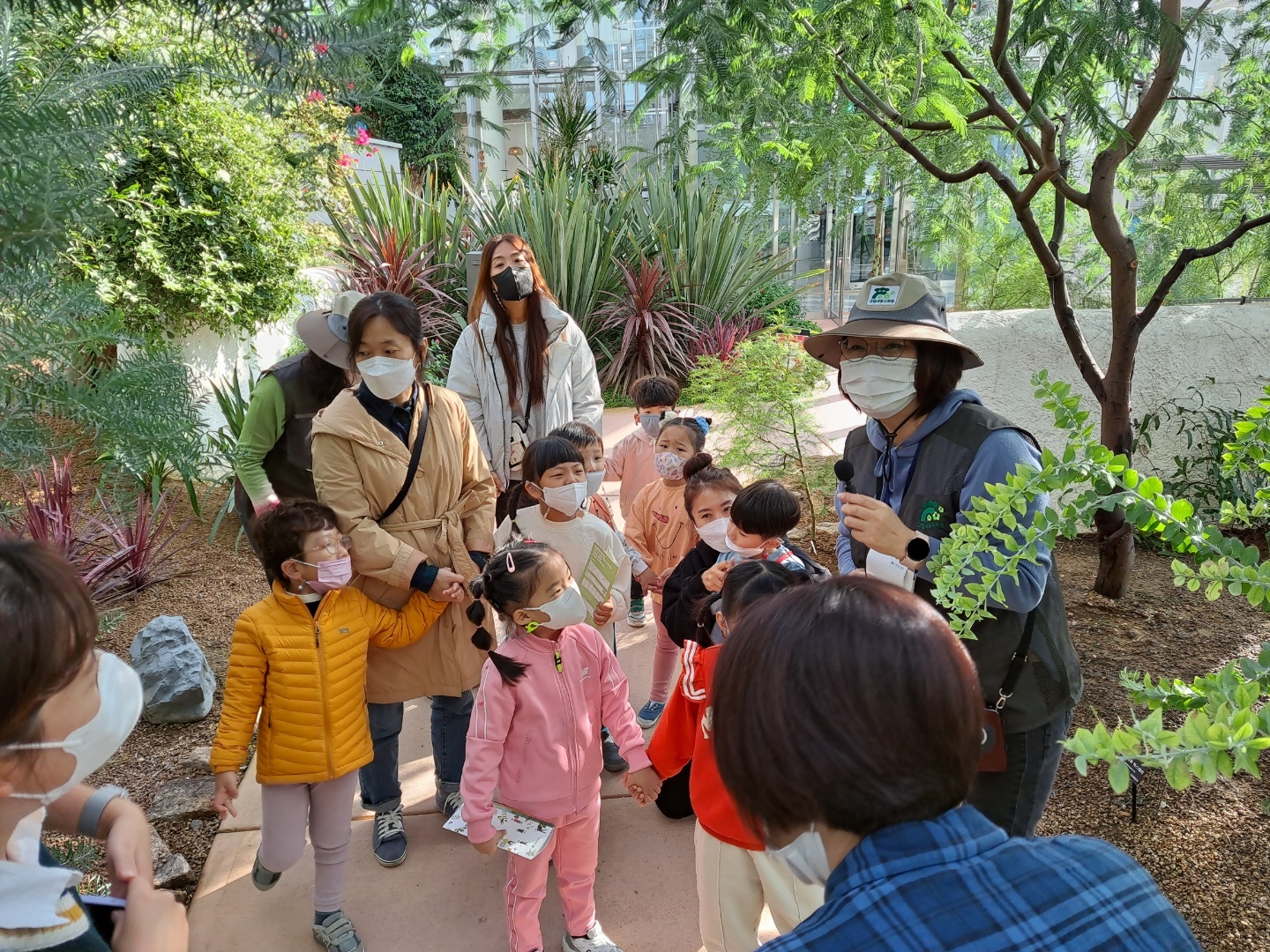 유치원 아이들이 온실 해설을 듣고 있는 사진