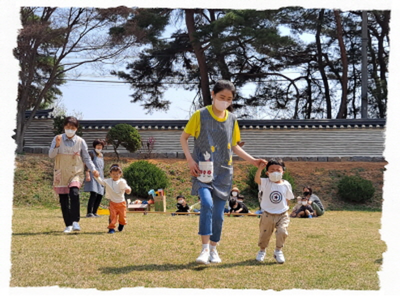 선생님이 아이들 손을 잡고 반화전으ㅡㄹ 향애 뛰어가고 있어요.