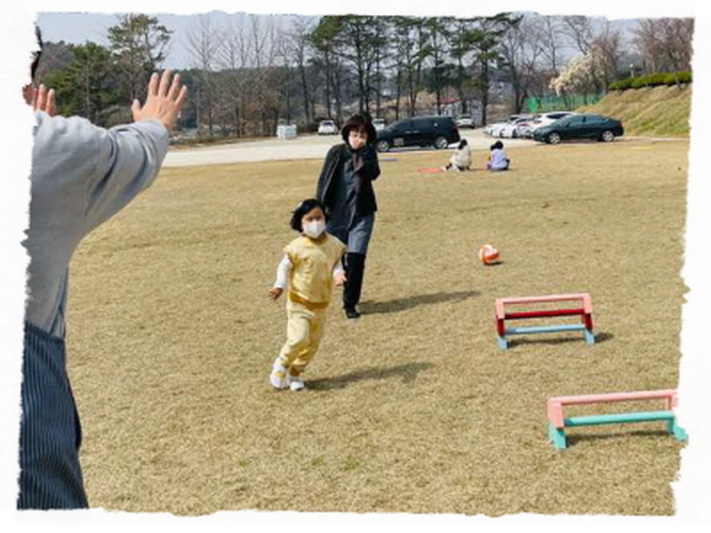 한명의 아동이 반환점을 돌아 뛰어오고 있어요