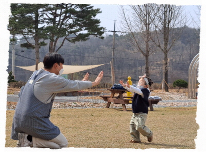 달리기를 다한 아동이 선생님과 마주 손뼉치기를 하고 있어요.