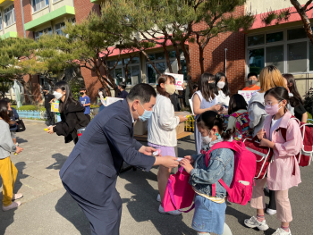 수곡초 어린이날 100주년 축제-1 수곡초 교장 한백순이 학생들에게 간식 꾸러미를 선물하고 있다.(2).jpg